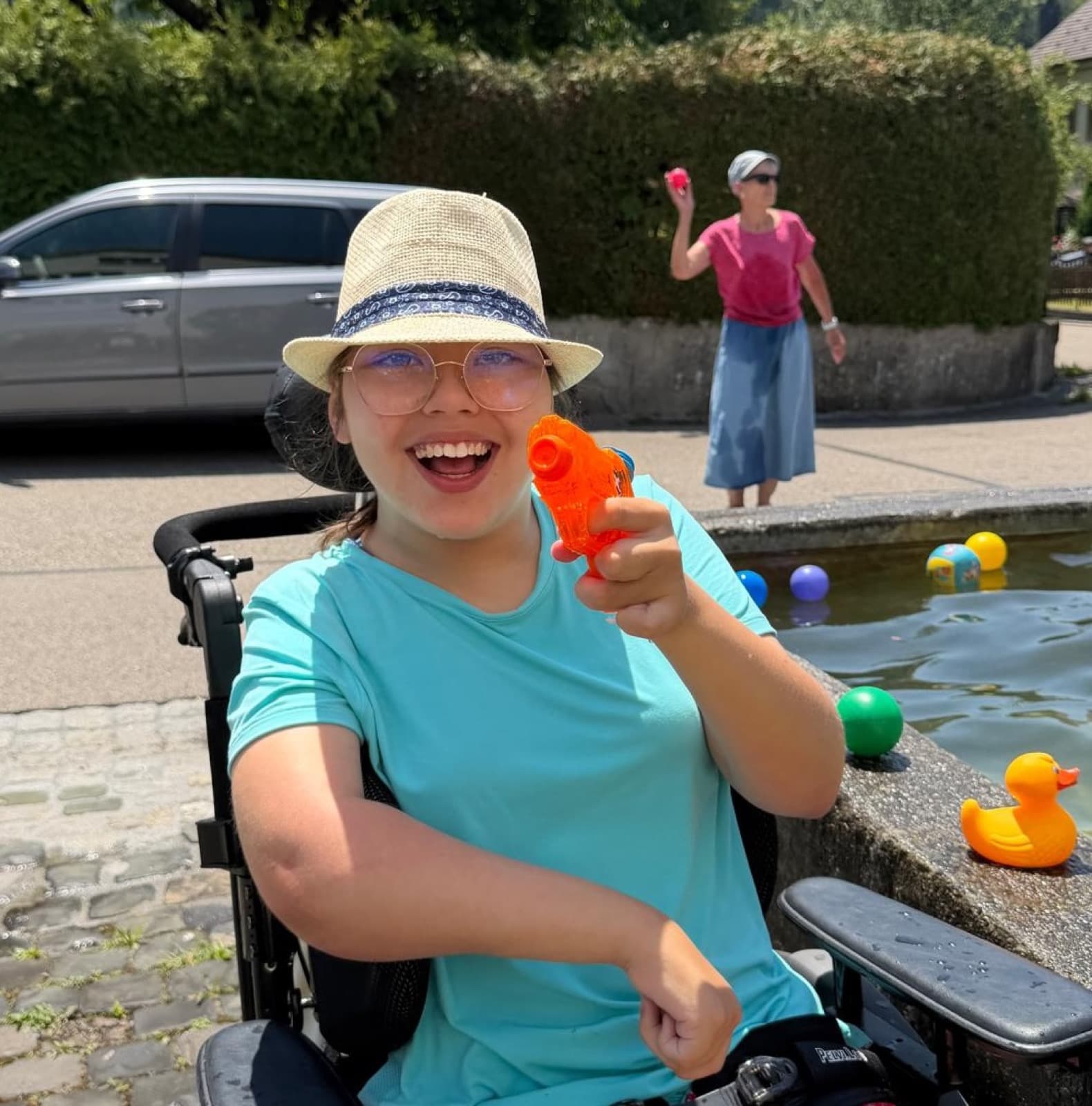 Bewaffnet mit Wasserpistole am Brunnen